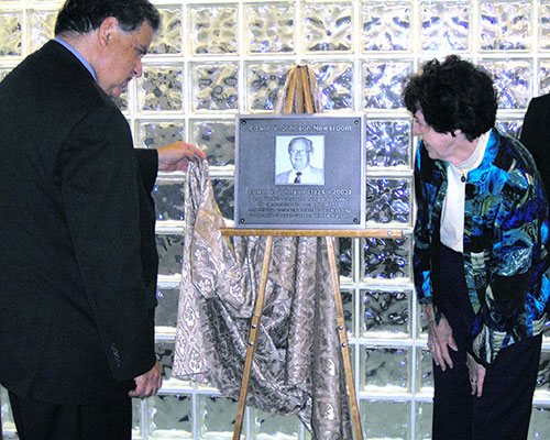 Mayor James J. Fiorentini and Pat Johnson unveil the Edwin V. Johnson Newsroom plaque.